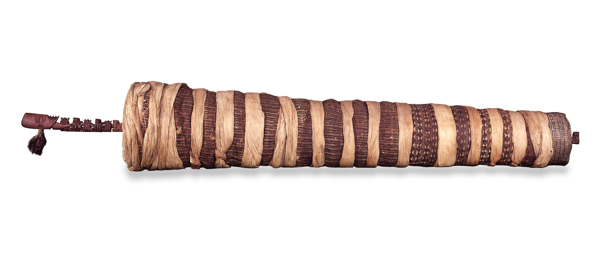 Ancestral polee, wrapped in alternating light and dark strips of material.